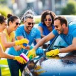 A group of adults laughing and having fun while washing a car together using colorful sponges and spraying each other with water in Danish is  En gruppe voksne der griner og har det sjovt mens de vasker en bil sammen med farverige svampe og sprøjter vand på hinanden